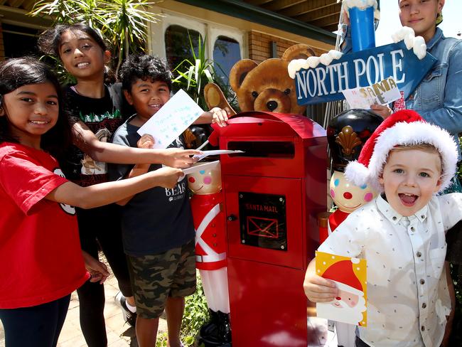 Kids in western Sydney have been dropping their letters to Santa at a special mailbox at the home of Linda Hernando in Emu Plains who takes the time to reply on behalf of Santa to each letter that is posted. L-R The Nagaretman siblings Amisha 9, Nishelle 12 and Michael 8 with Lucienne Heffernann 12 and Alex Peatman 4 post their letters to Santa.  Picture: Toby Zerna