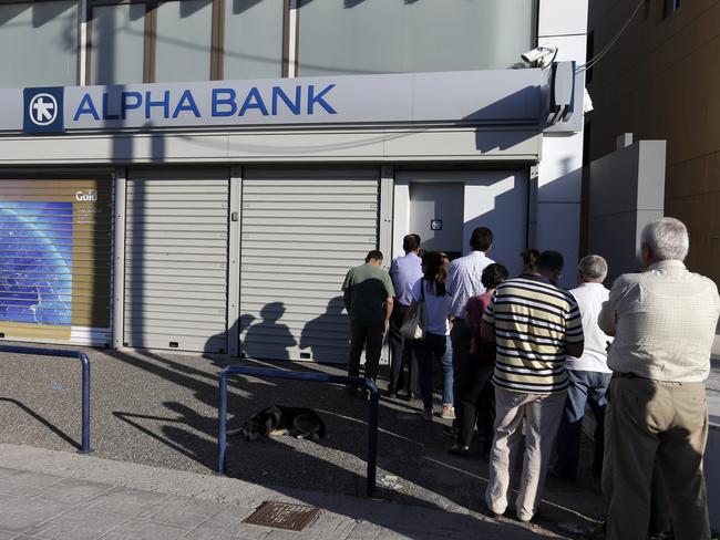 People stand in a queue to use an ATM of a bank during the referendum day voting in Athens. Pic: Thanassis Stavrakis