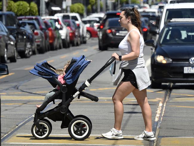 MELBOURNE, AUSTRALIA - NewsWire Photos NOVEMBER 04, 2021: A woman and baby in a pram walk across Glenferrie Road in the Melbourne suburb of Malvern. Picture: NCA NewsWire / Andrew Henshaw