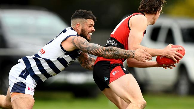 Jaxson Kinnear of Romsey is tackled by Hamish Govan of Macedon during the round 16 Riddell District Football Netball League 2023 Bendigo Bank Seniors match between Romsey and Macedon at Romsey Park in Romsey, Victoria on August 5, 2023. (Photo by Josh Chadwick)