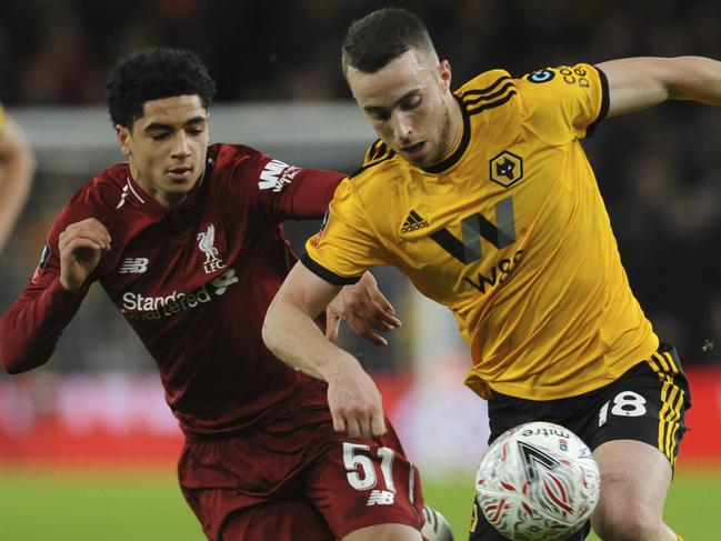 Liverpool's Ki-Jana Hoever, left, vies for the ball with Wolverhampton's Diogo Jota during the English FA Cup third round soccer match between Wolverhampton Wanderers and Liverpool at the Molineux Stadium in Wolverhampton, England, Monday, Jan. 7, 2019. (AP Photo/Rui Vieira)