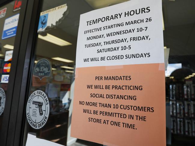 Signs on the front doors of Dukes Sport Shop in Pennsylvania show the hours and conditions to reopen. Picture: AP