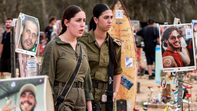 Female Israeli army soldiers walk at a memorial for the victims killed at or kidnapped from the Supernova music festival during the October 7. Picture: Menahem Kahana / AFP