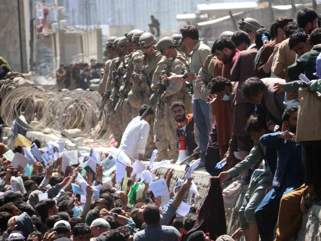 epaselect epa09430526 Afghans struggle to reach the foreign forces to show their credentials to flee the country outside the Hamid Karzai International Airport, in Kabul, Afghanistan, 26 August 2021. At least 13 people including children were killed in a blast outside the airport on 26 August. The blast occurred outside the Abbey Gate and follows recent security warnings of attacks ahead of the 31 August deadline for US troops withdrawal.  EPA/AKHTER GULFAM