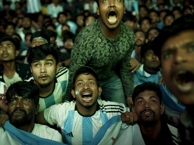 In the Dhaka University area of Bangladesh, an animated crowd gathers to watch the FIFA World Cup Qatar 2022 match between Argentina and Poland on a big screen in the street. Picture: K Asad