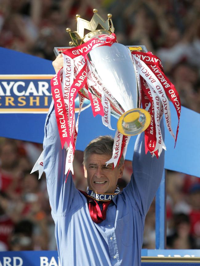 Arsene Wenger holds up the Premier League trophy.