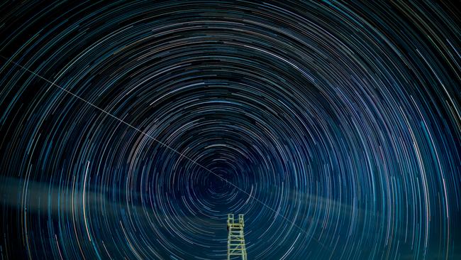 A stack of 200 images x 40 seconds long exposures blended together in Photoshop to complete a composite of star trails over the shark tower at Redhead Beach. The centre of the star trail is the celestial south pole around which the earth rotates. The white streak is the International Space Station passing through the image. Shot with a Nikon Z611 camera. Click on the photo to view in full screen. Picture: Ron Bonham