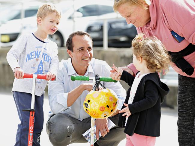 Mr Sharma talking to locals Miriam Chemler, Hugo Ward, four, and Alexis Chemler, two at Bondi Beach this week. Picture: Adam Yip