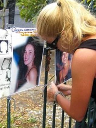 Maria attaches pictures of her sisters and cousins to the fence of the Sari Club in Bali, where they died in the 2002 bombings.