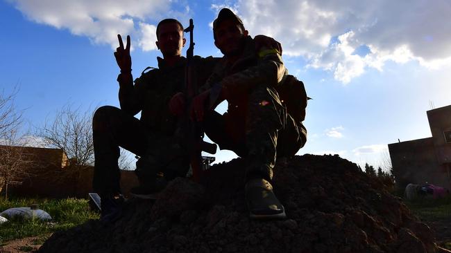 Fighters from the Syrian Democratic Forces gesture the victory sign near Baghouz in Syria. Picture: AFP