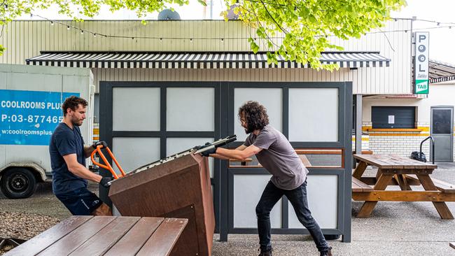 Notting Hill Hotel workers shift an outdoor foosball table as they prepare to close the pub. Picture: Asanka Ratnayake/Getty Images