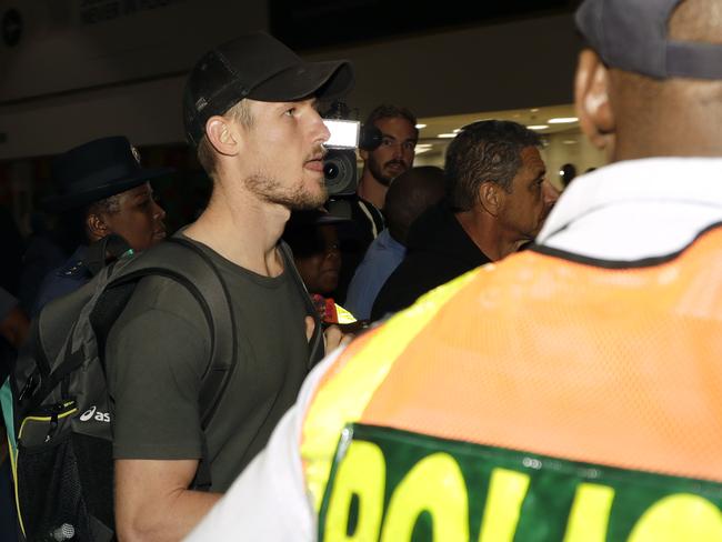 Bancroft being ushered through South African airport.