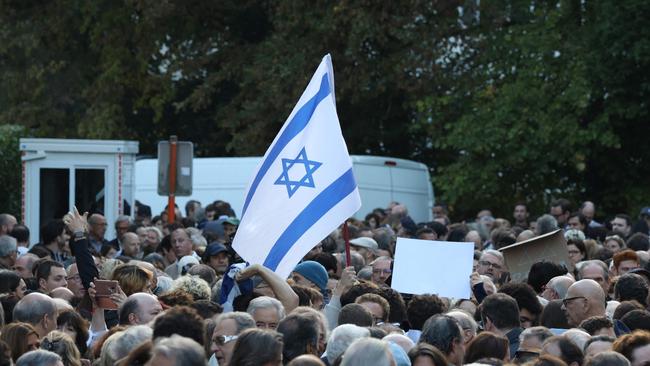 A protester waves an Israeli national flag during a rally in support of the people of Israel. (Photo by Simon Wohlfahrt / AFP)