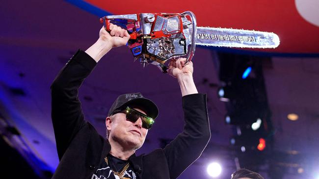 OXON HILL, MARYLAND - FEBRUARY 20: CEO of Tesla and SpaceX Elon Musk wields a chainsaw as he leaves the stage alongside Newsmax anchor Rob Schmitt at the Conservative Political Action Conference (CPAC) at the Gaylord National Resort Hotel And Convention Center on February 20, 2025 in Oxon Hill, Maryland. The annual four-day gathering brings together conservative U.S. lawmakers, international leaders, media personalities and businessmen to discuss and champion conservative ideas. Argentinian President Javier Milei gifted Musk the chainsaw that he used as a prop while campaigning.   Andrew Harnik/Getty Images/AFP (Photo by Andrew Harnik / GETTY IMAGES NORTH AMERICA / Getty Images via AFP)