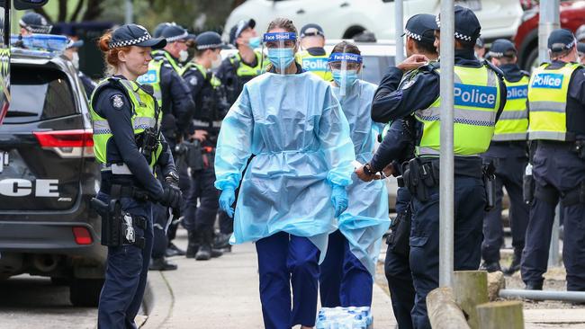 Medical staff wearing PPE walk into the Flemington Public housing flats. Picture: Getty