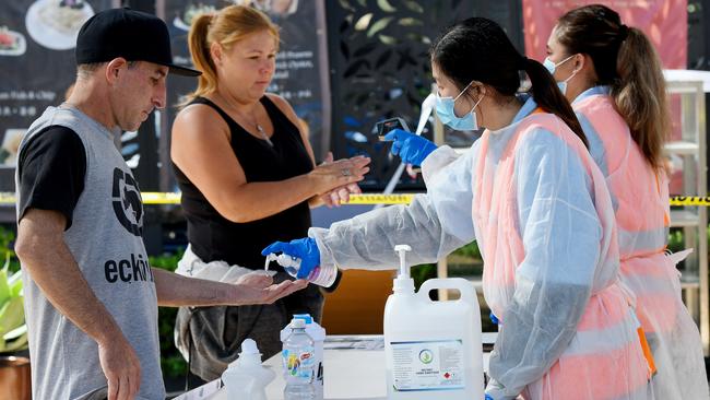 People are given hand sanitiser and have their temperatures checked before entering the Sydney Fish Market on Good Friday. Picture: Bianca De Marchi/AAP