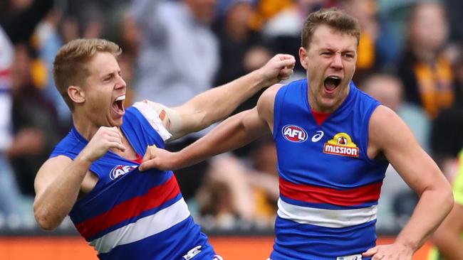 Jack Macrae and Lachie Hunter celebrate a goal as Western Bulldogs stormed over Hawthorn on Sunday. Picture: Scott Barbour/AFL Photos/Getty Images.