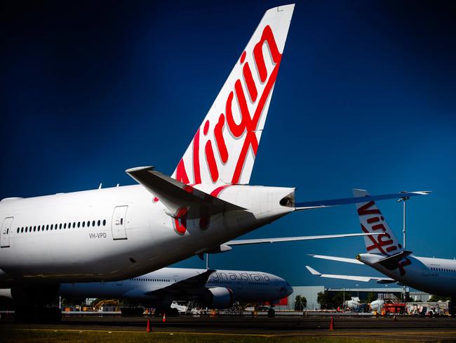 Virgin Australia aircraft are seen parked on the tarmac at Brisbane International airport on April 21, 2020. - Cash-strapped Virgin Australia collapsed on April 21, making it the largest carrier yet to buckle under the strain of the coronavirus pandemic, which has ravaged the global airline industry. (Photo by Patrick HAMILTON / AFP)