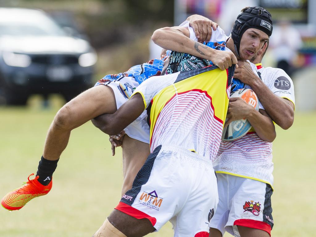 Chris Woodbridge of Coastal Blacks is lifted in a tackle by SEQ Magic players in the Warriors Reconciliation Knockout Carnival at Jack Martin Centre. Picture: Kevin Farmer