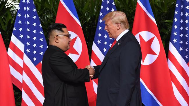 North Korea's leader Kim Jong Un (L) shakes hands with US President Donald Trump (R) at the start of their historic US-North Korea summit, at the Capella Hotel on Sentosa island in Singapore on June 12, 2018. Donald Trump and Kim Jong Un have become on June 12 the first sitting US and North Korean leaders to meet, shake hands and negotiate to end a decades-old nuclear stand-off. / AFP PHOTO / SAUL LOEB