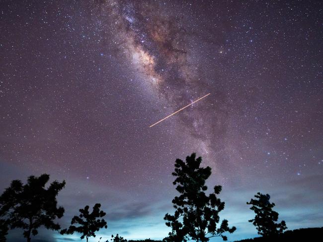 A flight-illuminated path and the Milky Way are appearing in the night sky during the Eta Aquarids meteor shower, which is peaking in Ratnapura, Sri Lanka, on May 5, 2024. The Eta Aquarids Meteor Shower is an annual event caused by Earth passing through debris left behind by Halley's Comet. Named after the constellation Aquarius, these meteors are streaking across the sky at high speeds, creating a dazzling display of shooting stars. Best observed in the predawn hours away from city lights, it is a mesmerizing celestial event cherished by skywatchers worldwide. (Photo by Thilina Kaluthotage/NurPhoto via Getty Images)