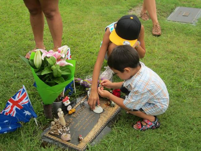 Omega Ruston's children, Tylah and Tommy, visit his grave.