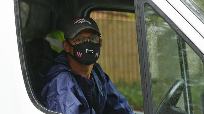 A masked courier leaves the Baptist Care Macquarie Park. Picture: John Appleyard