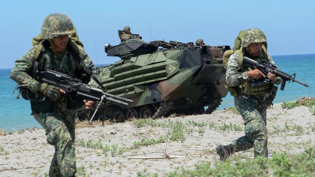 Philippines marines take position next to a US amphibious assault vehicle during an exercise in 2018.