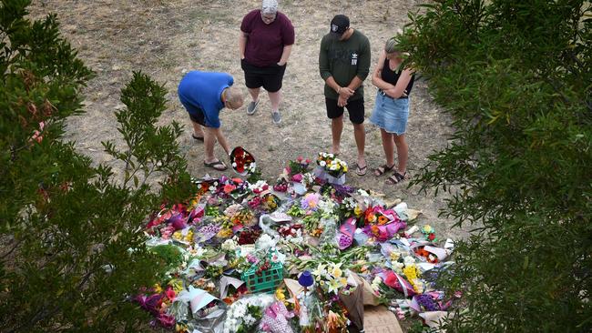 People gather and lay flowers at the site where Aiia Maasarwe was murdered. Picture: Tony Gough