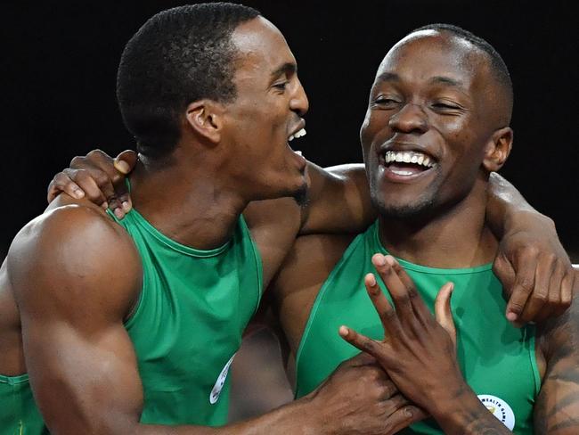 TOPSHOT - South Africa’s Henricho Bruintjies (silver)  and South Africa’s Akani Simbine (gold) celebrate after the athletics men's 100m final during the 2018 Gold Coast Commonwealth Games at the Carrara Stadium on the Gold Coast on April 9, 2018. / AFP PHOTO / SAEED KHAN