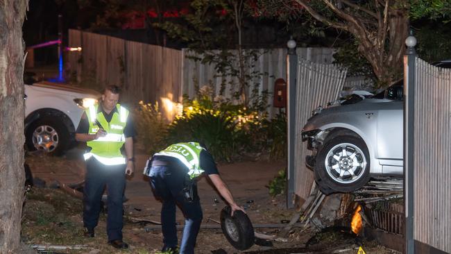 Police pick up a wheel that came off during the crash. Picture: Jason Edwards