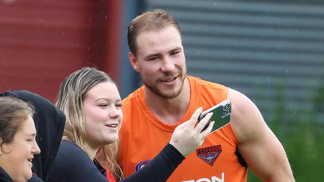 New Bombers recruit Ben McKay takes a photo with a fan. Picture: Ian Currie