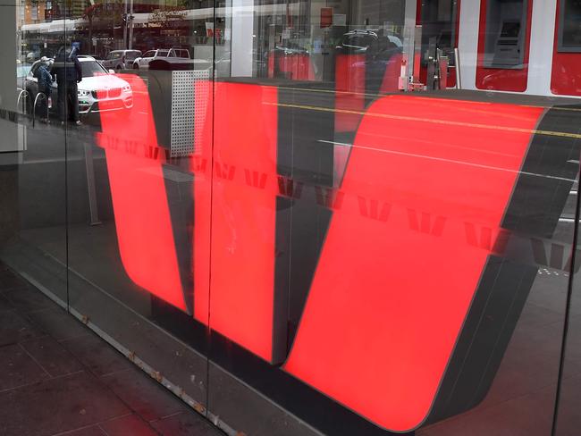 A man walks past a Westpac bank sign in Melbourne's central business district on May 4, 2020. - Westpac on May 4 announced its half-year net profit had fallen 62 percent, making it the latest Australian bank to see profits dive during the coronavirus crisis. (Photo by William WEST / AFP)