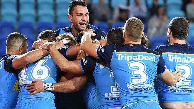 Ryan James, centre, and his Titans teammates celebrate the winning try against the Canberra Raiders.