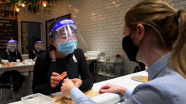 Nail Technician Lily Nguyen wears a mask and face shield while tending to a customer at the Depot Nail in Sydney’s Broadway Shopping Centre. Picture: Getty Images