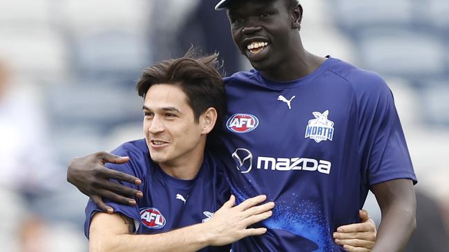 GEELONG, AUSTRALIA - APRIL 14: Zac Fisher share an embrace with Bigoa Nyuon of the Kangaroos before the round five AFL match between Geelong Cats and North Melbourne Kangaroos at GMHBA Stadium, on April 14, 2024, in Geelong, Australia. (Photo by Darrian Traynor/Getty Images)