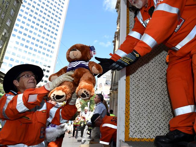 A teddy bear left at the memorial is carefully handled. Picture: Nicole Garmston