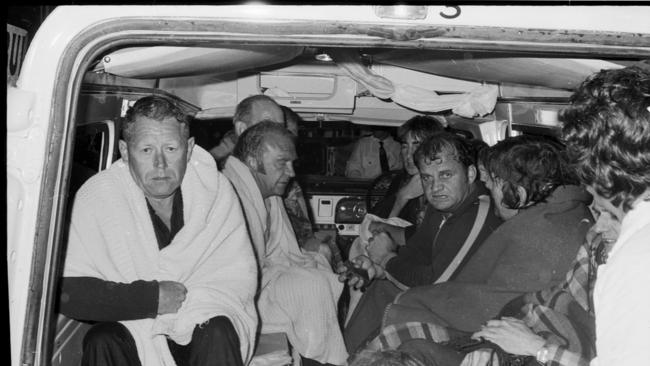 Crew members huddle in an ambulance after being rescued from the sinking Lake Illawarra bulk ore carrier after it struck Hobart's Tasman Bridge.