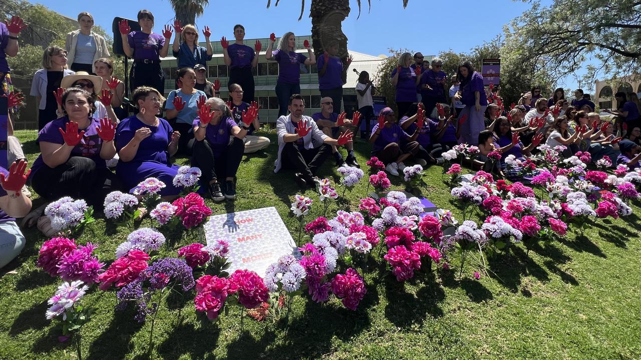 Crowds dipped their palms in red at the Day of Action against family and domestic violence rally at the Alice Springs court house lawns. Picture: Fia Walsh