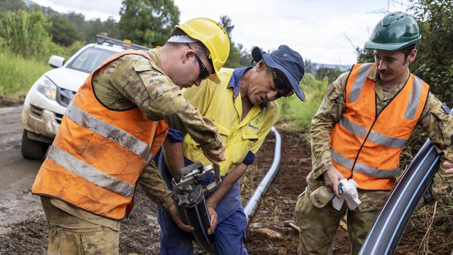 Australian Army soldiers Sapper Brayden Taylor (left) and Sapper Daniel Coleman work with Lismore City Council worker Ian Mackie to restore water to Nimbin. Picture: Australian Defence Force