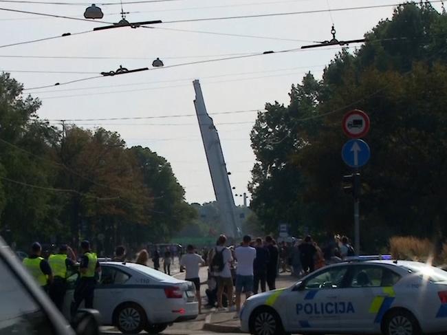 Onlookers during the downing of the monument in Latvia.