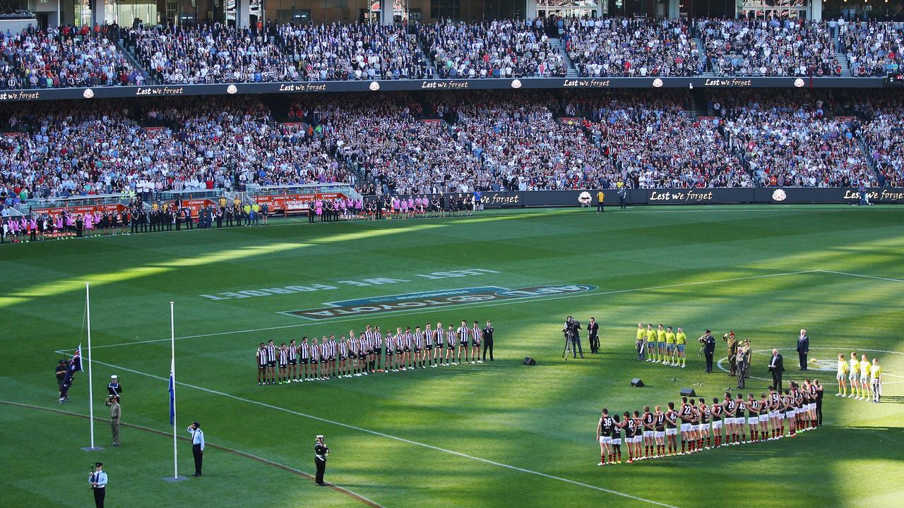 MELBOURNE, AUSTRALIA - APRIL 25: The players and crowd stand for a minutes silence in tribute to Anzac Day during the round five AFL match between the Collingwood Magpies and the Essendon Bombers at Melbourne Cricket Ground on April 25, 2016 in Melbourne, Australia. (Photo by Michael Dodge/Getty Images)