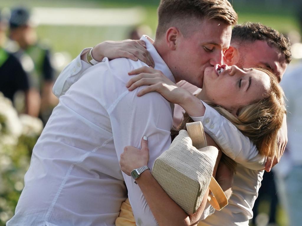 A couple embrace at Flemington after the big race. Picture: AAP/Scott Barbour