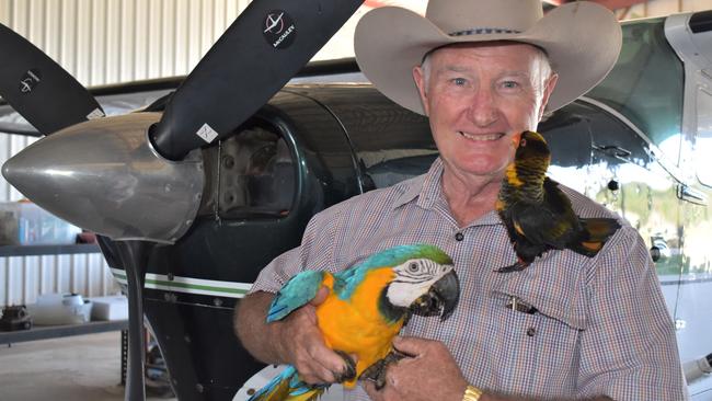 Whitsunday Park Estate developer Garry Poole with his pet Macaw, Bluey, and Indonesian Dusky Lory, Screech, standing in front of his Cessna 206 plane. Picture: Heidi Petith
