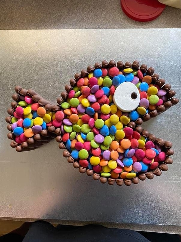 To create the fish-shaped cake she used the popular white mud cake from the retailer. Picture: Facebook/Woolies/Coles Mudcake Hacks