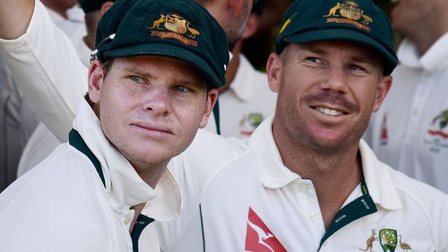 (FILES) In this file picture taken on February 20, 2016, Steve Smith (L) captain of Australia and teammate David Warner (R) wait to start the days play during day one of the second cricket Test match between New Zealand and Australia at the Hagley Park in Christchurch. Cricket Australia confirmed one year bans for Steve Smith and David Warner on March 28, 2018, following revelations concerning ball-tampering. / AFP PHOTO / Marty MELVILLE