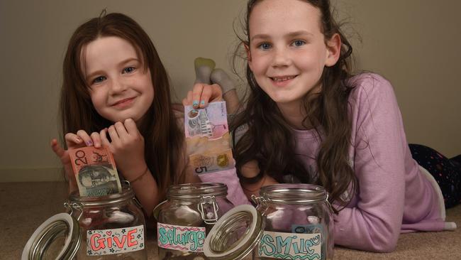 Olivia and Georgia May with their splurge, smile and give jars. Picture: Tony Gough