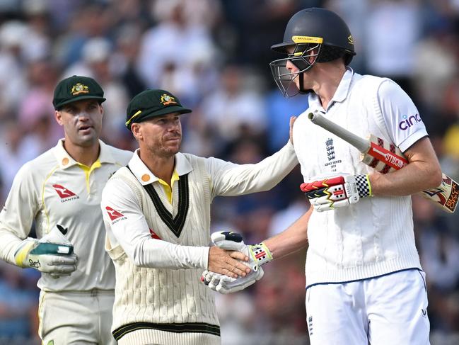 David Warner (C) congratulates Zak Crawley (R) after he loses his wicket for 189 runs. Picture: AFP