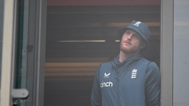 A dejected Ben Stokes looks on from the balcony as rain washes out the final day’s play in Manchester. Picture: AFP