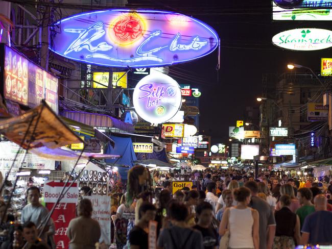 "Bangkok, Thailand - July 23, 2012: Nighttime crowd at Khao San Road in Bangkok. Many people can be seen walking amongst bars and street stalls in this famous tourist district with neon signs overhead."